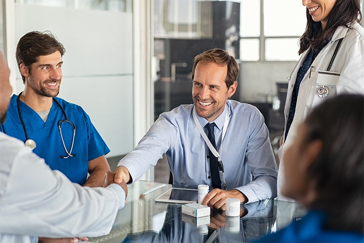 Healthcare professionals meeting with a pharmaceutical sourcing representative